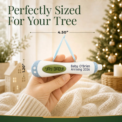 Size guide: the personalized Pregnancy Test Baby Boy christmas ornament shown in hand next to a Christmas tree