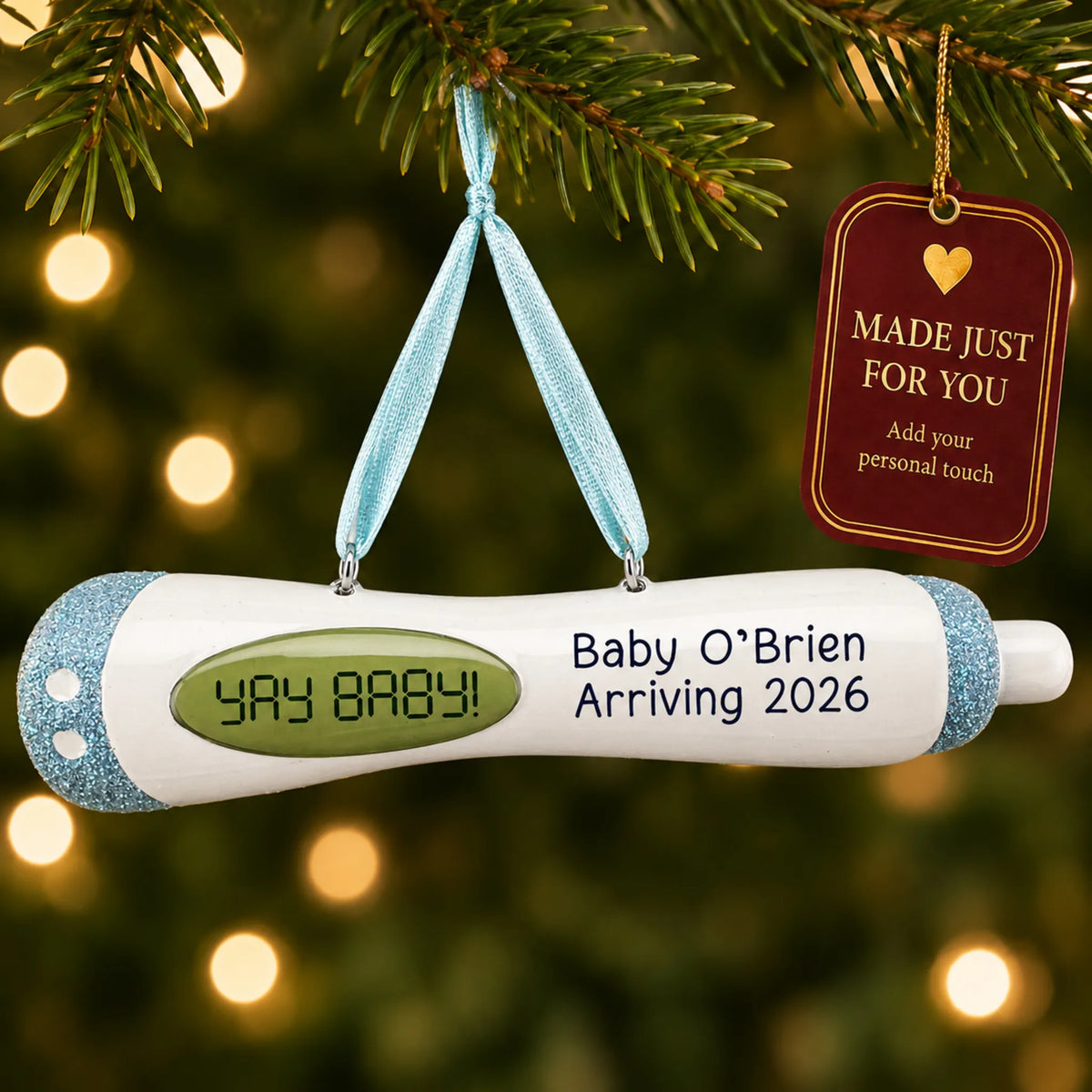 Pregnancy Test Baby Boy christmas ornament hanging on a lit Christmas tree with a Made Just For You gift tag