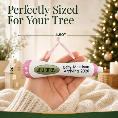 Size guide: the personalized Pregnancy Test Baby Girl christmas ornament shown in hand next to a Christmas tree