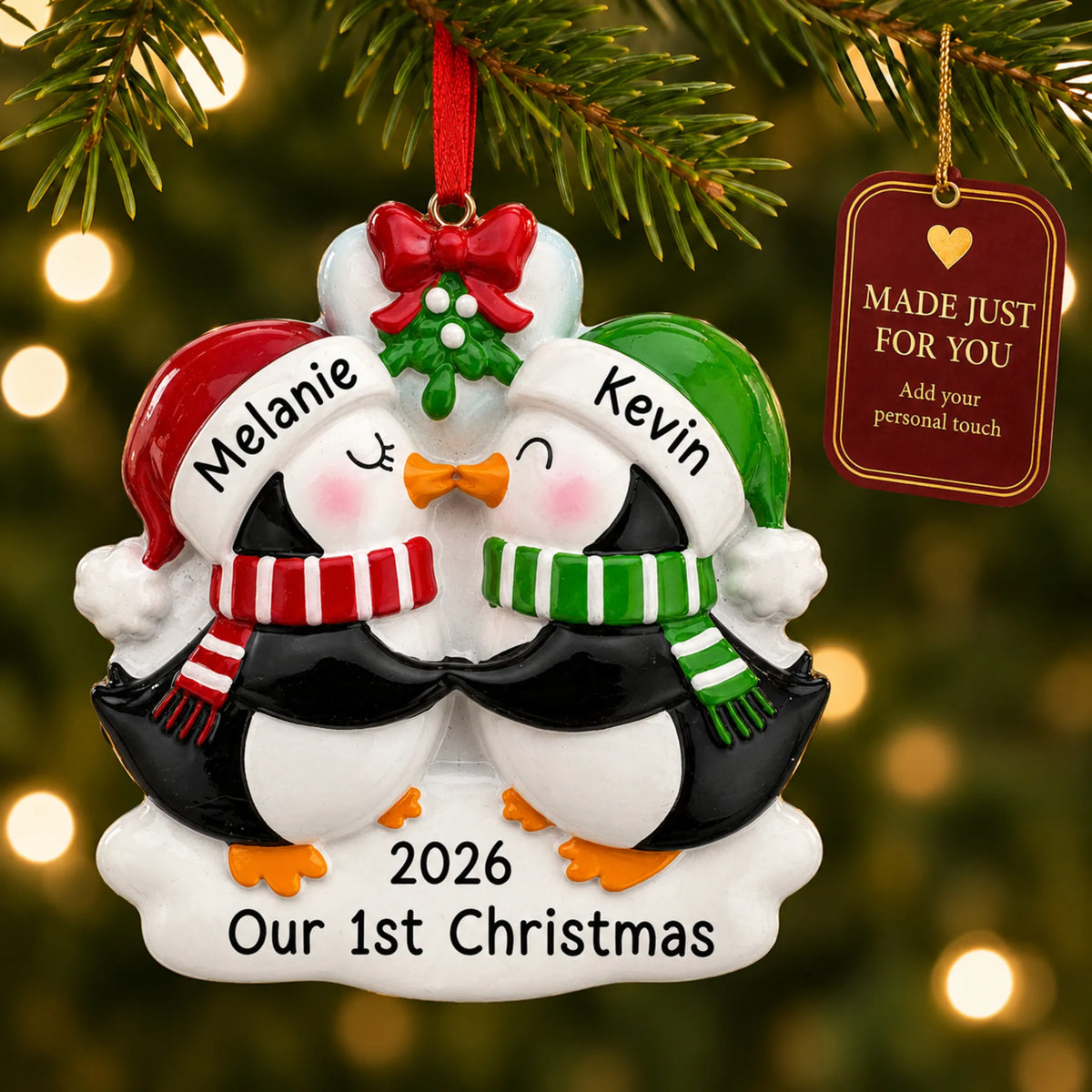 Penguin mistletoe kisses couple christmas ornament hanging on a lit Christmas tree with a Made Just For You gift tag