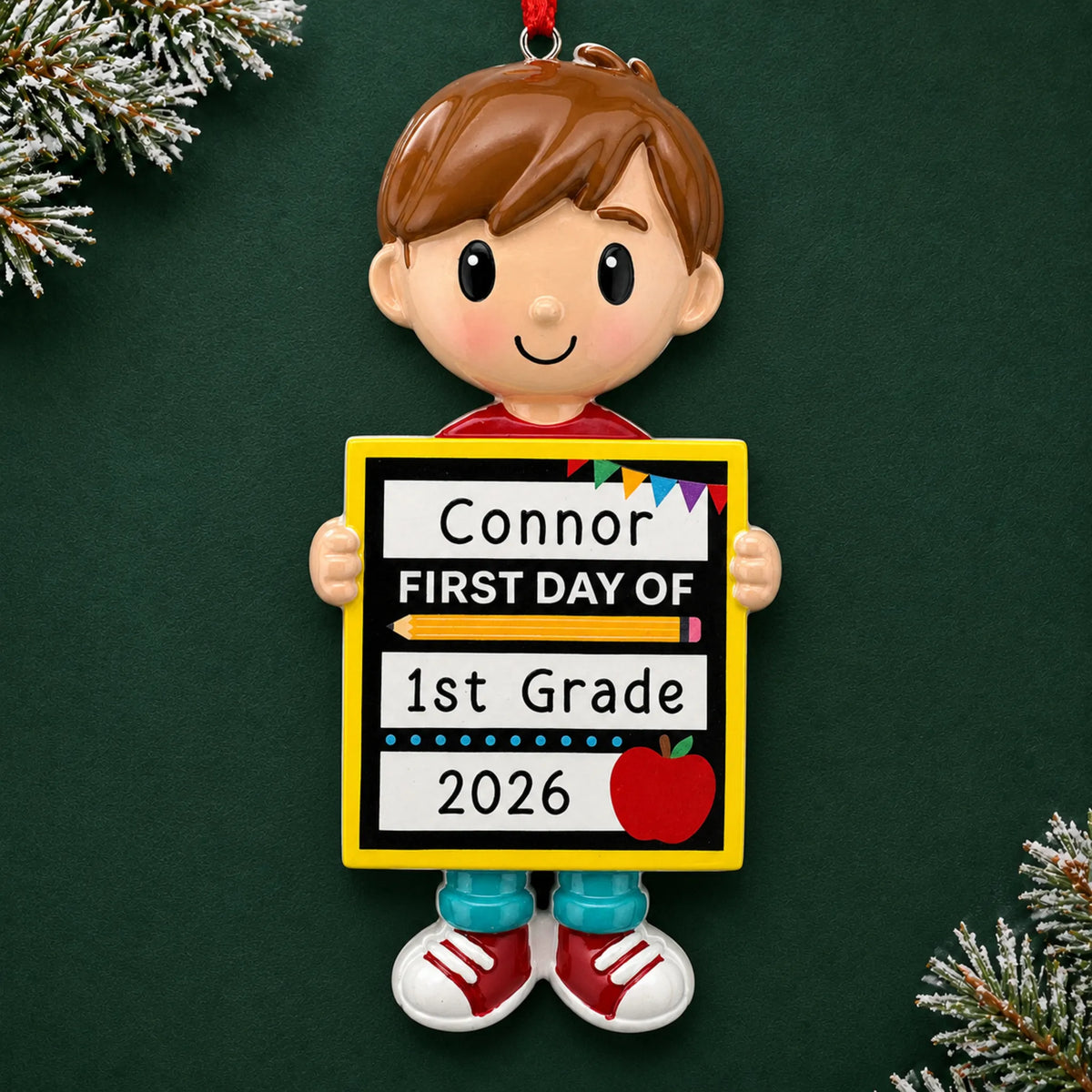 Personalized first day of school boy Christmas ornament with name and year, shown on a green holiday background