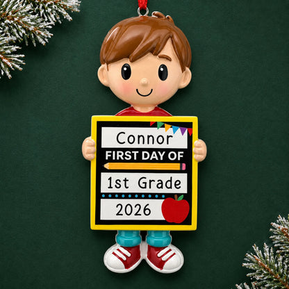 Personalized first day of school boy Christmas ornament with name and year, shown on a green holiday background