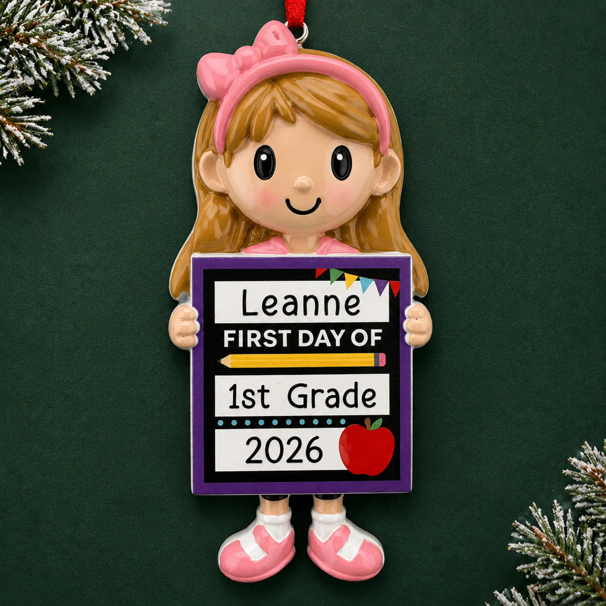 Personalized first day of school girl Christmas ornament with name and year, shown on a green holiday background