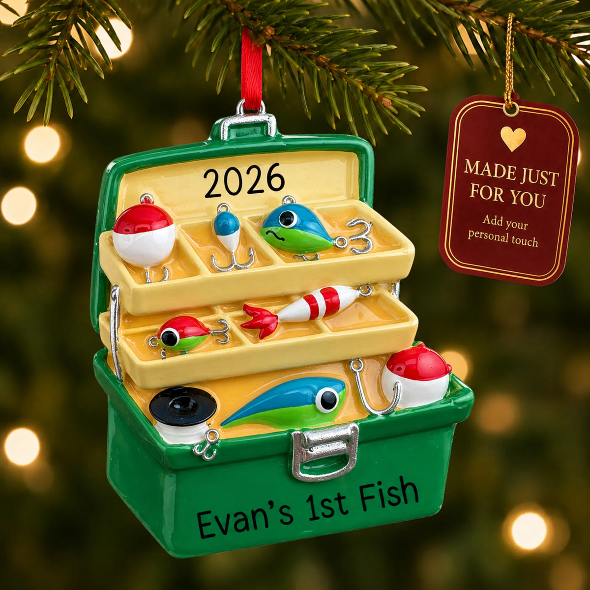 Green fishing tackle box christmas ornament hanging on a lit Christmas tree with a Made Just For You gift tag