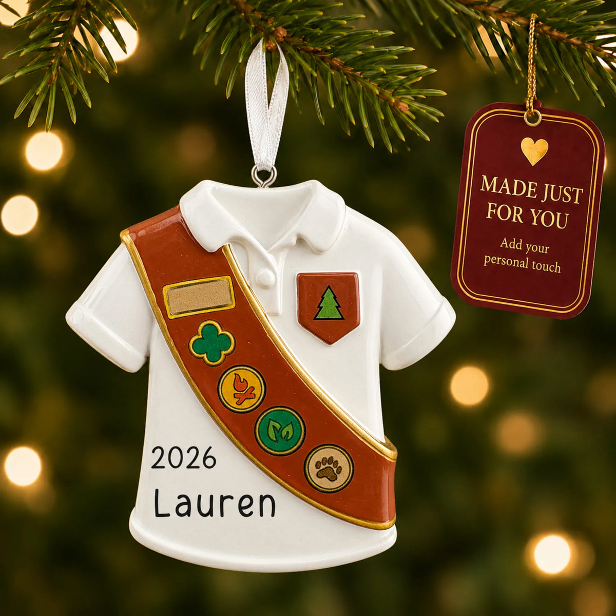 Girl Scout brown sash christmas ornament hanging on a lit Christmas tree with a Made Just For You gift tag