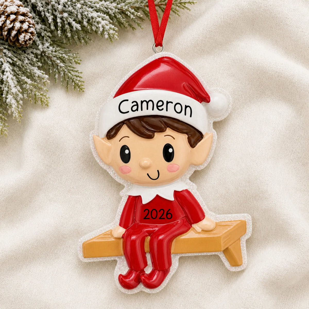 Personalized Christmas Elf ornament laid on a soft white knit blanket