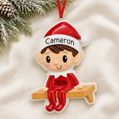 Personalized Christmas Elf ornament laid on a soft white knit blanket
