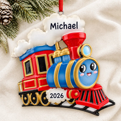 Personalized kids train christmas ornament laid on a soft white knit blanket