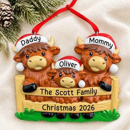 Personalized highland cow family of 3 christmas ornament laid on a soft white knit blanket