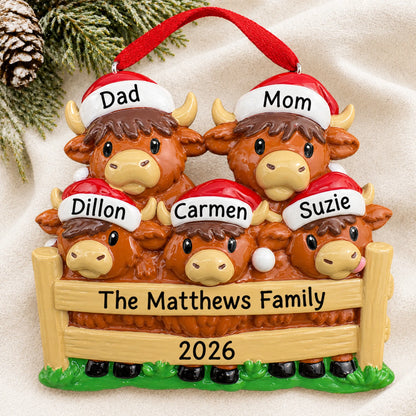 Personalized highland cow family of 5 christmas ornament laid on a soft white knit blanket