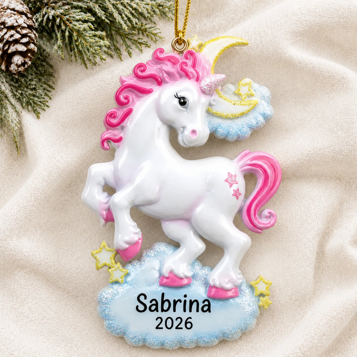 Personalized unicorn sparkles christmas ornament laid on a soft white knit blanket