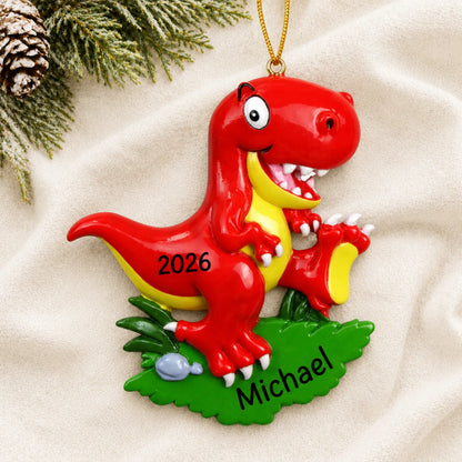 Personalized red t-rex christmas ornament laid on a soft white knit blanket