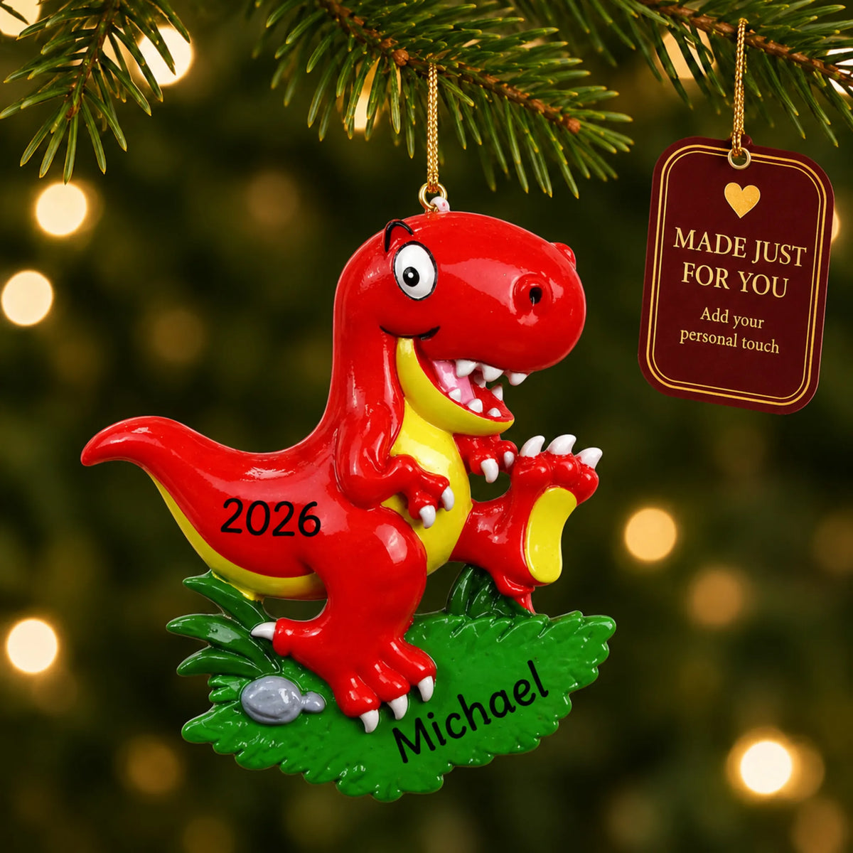 Red t-rex christmas ornament hanging on a lit Christmas tree with a Made Just For You gift tag