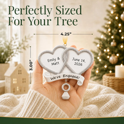 Personalized We're Engaged double heart Christmas ornament held in a hand to show its 4.25 by 3 inch size