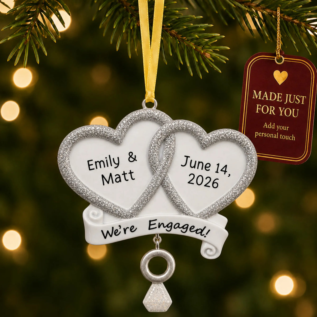 Personalized We're Engaged double heart Christmas ornament on a lit Christmas tree with a Made Just For You tag