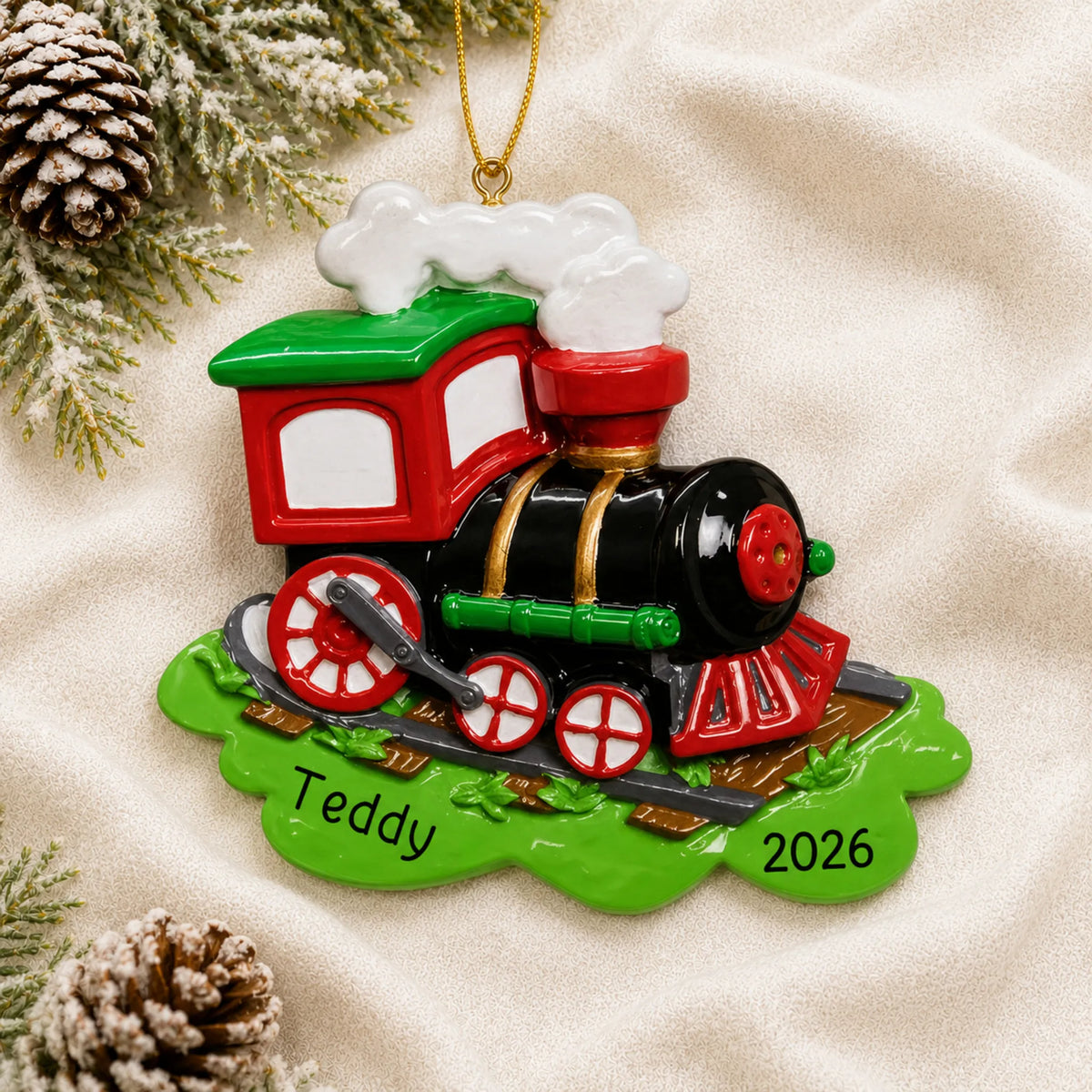 Personalized choo choo train christmas ornament laid on a soft white knit blanket