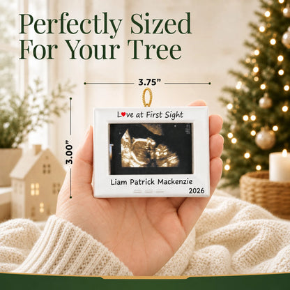 Size guide: the personalized New Baby Ultrasound Frame christmas ornament is 3.75 in wide by 3.00 in tall, shown in hand