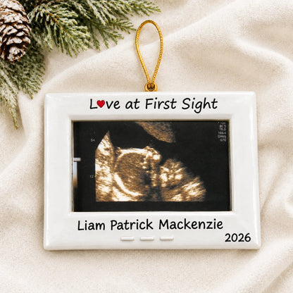 Personalized New Baby Ultrasound Frame christmas ornament laid on a soft white knit blanket