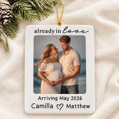 Personalized Expecting Couple Photo Frame christmas ornament laid on a soft white knit blanket