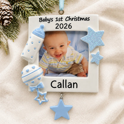 Personalized blue baby's first picture frame christmas ornament laid on a soft white knit blanket