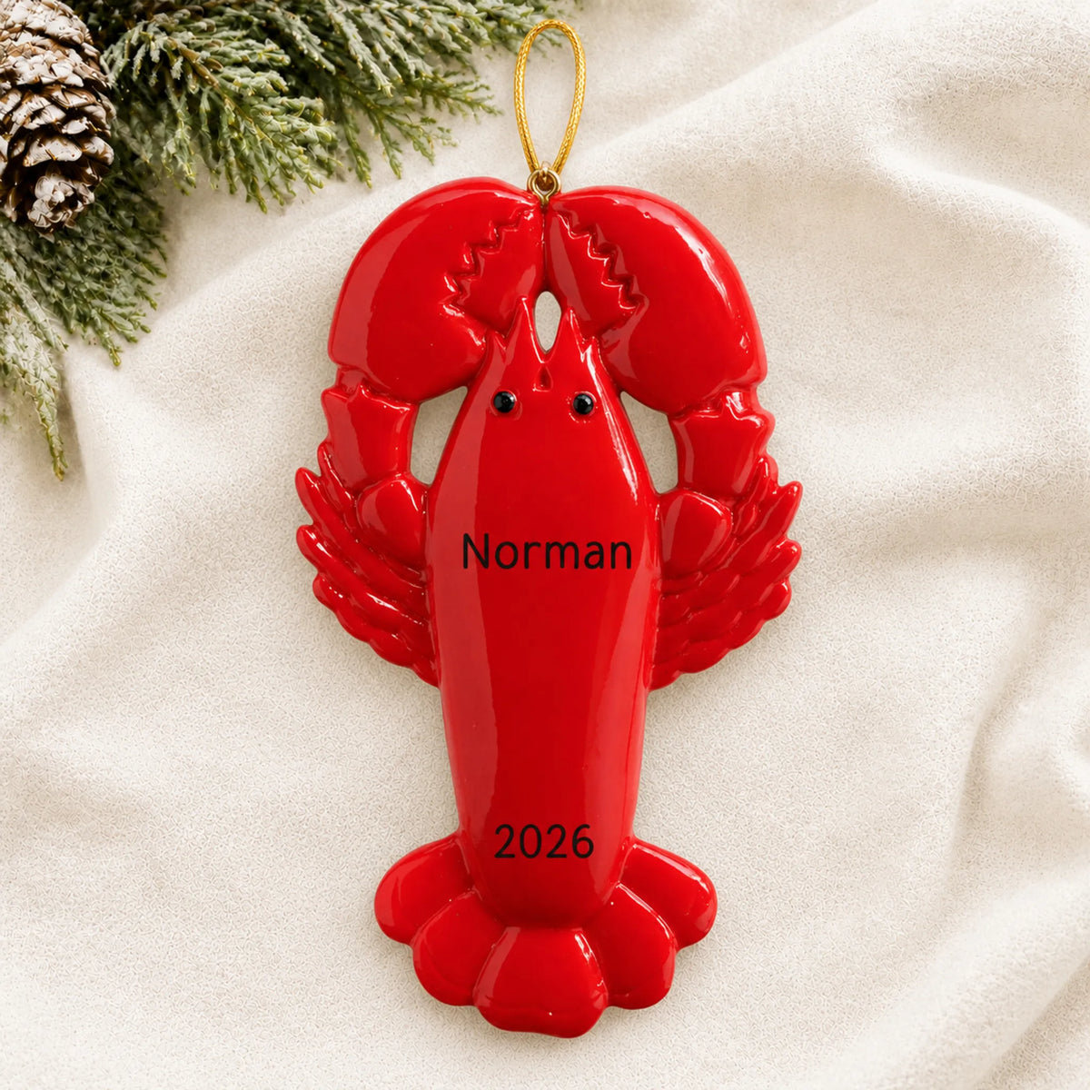 Personalized lobster christmas ornament laid on a soft white knit blanket