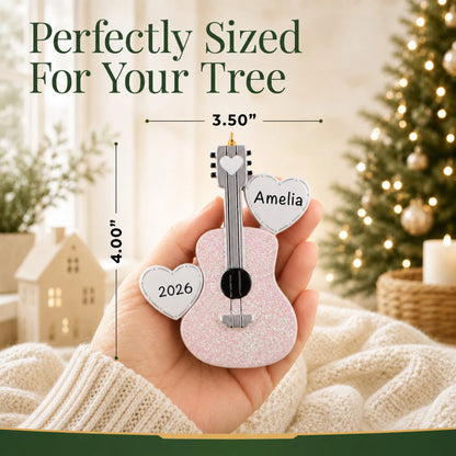 Size guide: the personalized pink guitar christmas ornament is 3.50 in wide by 4.00 in tall, shown in hand