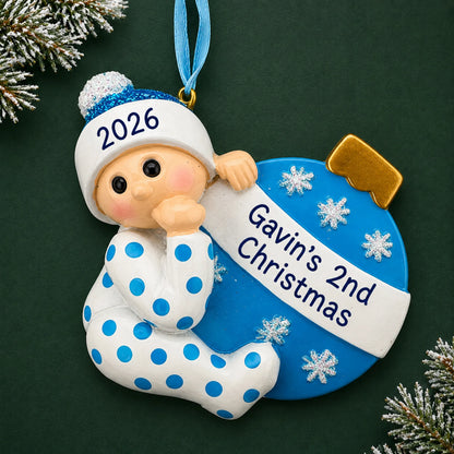 Personalized blue baby's 2nd christmas ornament on a dark green pine background