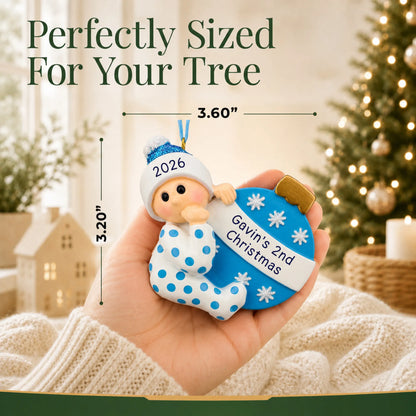 Size guide: the personalized blue baby's 2nd christmas ornament is 3.50 in wide by 3.75 in tall, shown in hand
