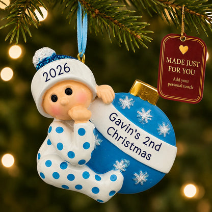 Blue baby's 2nd christmas ornament hanging on a lit Christmas tree with a Made Just For You gift tag
