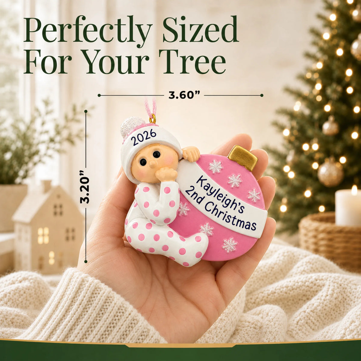 Size guide: the personalized pink baby's 2nd christmas ornament is 3.50 in wide by 3.75 in tall, shown in hand