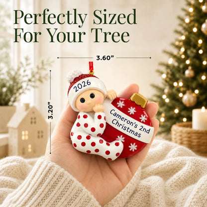 Size guide: the personalized red baby's 2nd christmas ornament is 3.50 in wide by 3.75 in tall, shown in hand