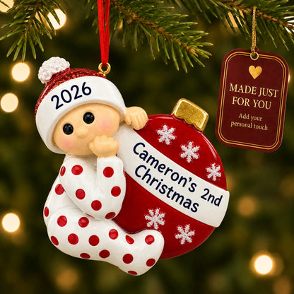Red baby's 2nd christmas ornament hanging on a lit Christmas tree with a Made Just For You gift tag