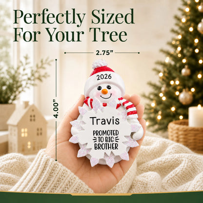 Size guide: the personalized promoted to big brother christmas ornament shown in hand next to a Christmas tree