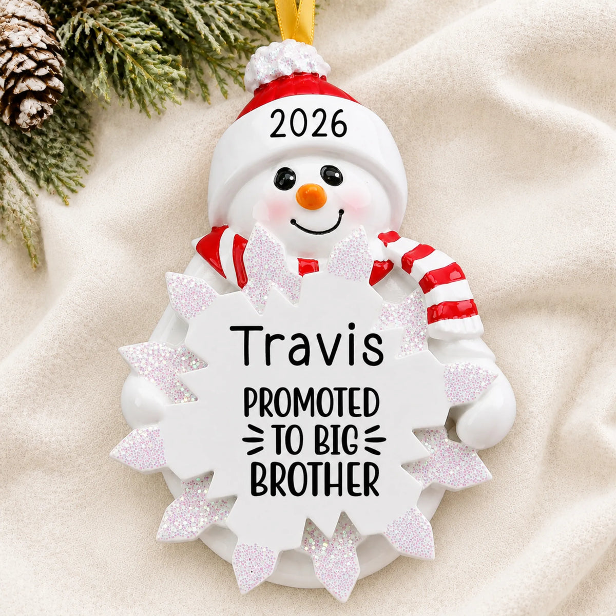 Personalized promoted to big brother christmas ornament laid on a soft white knit blanket