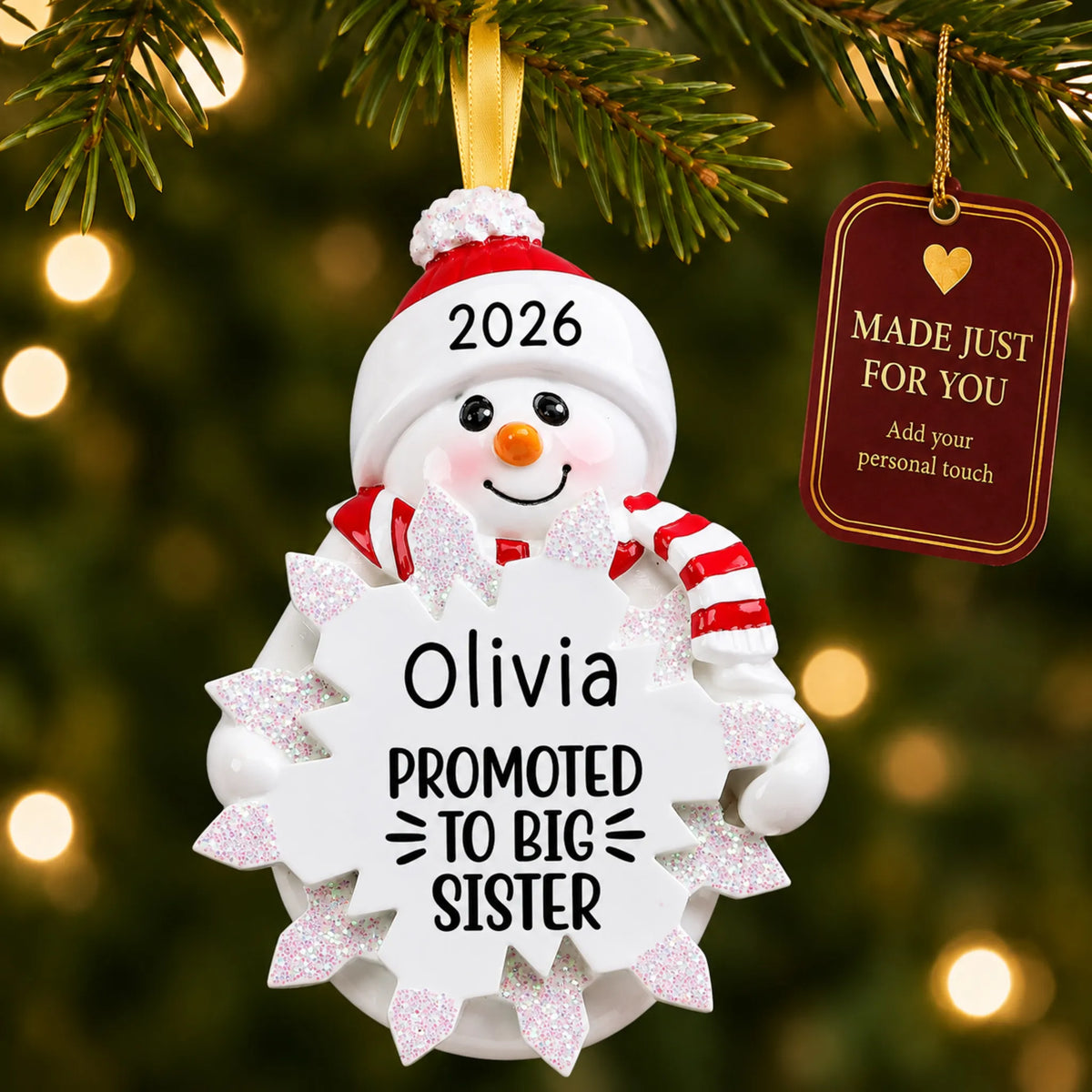 Promoted to big sister christmas ornament hanging on a lit Christmas tree with a Made Just For You gift tag