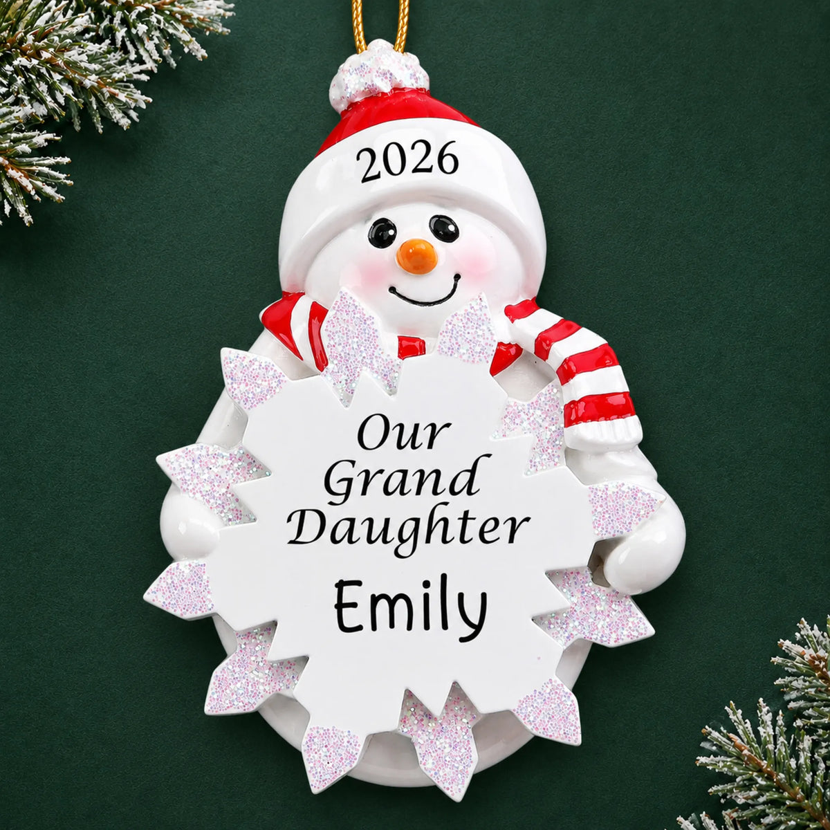 Personalized granddaughter snowman christmas ornament on a dark green pine background