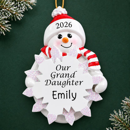 Personalized granddaughter snowman christmas ornament on a dark green pine background