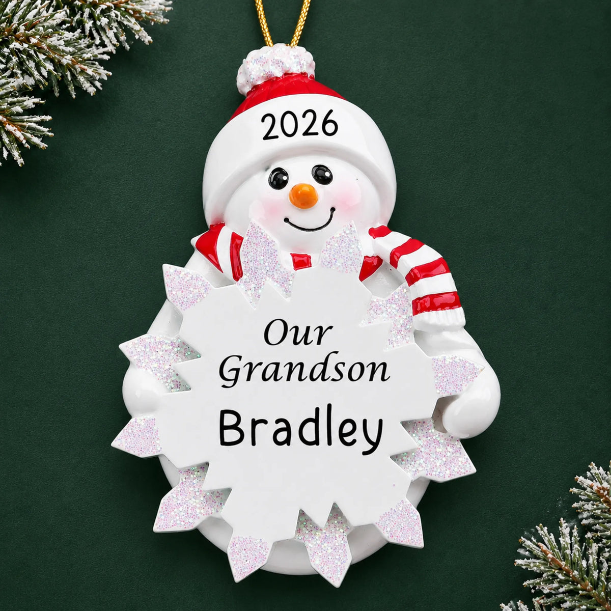 Personalized grandson snowman christmas ornament on a dark green pine background
