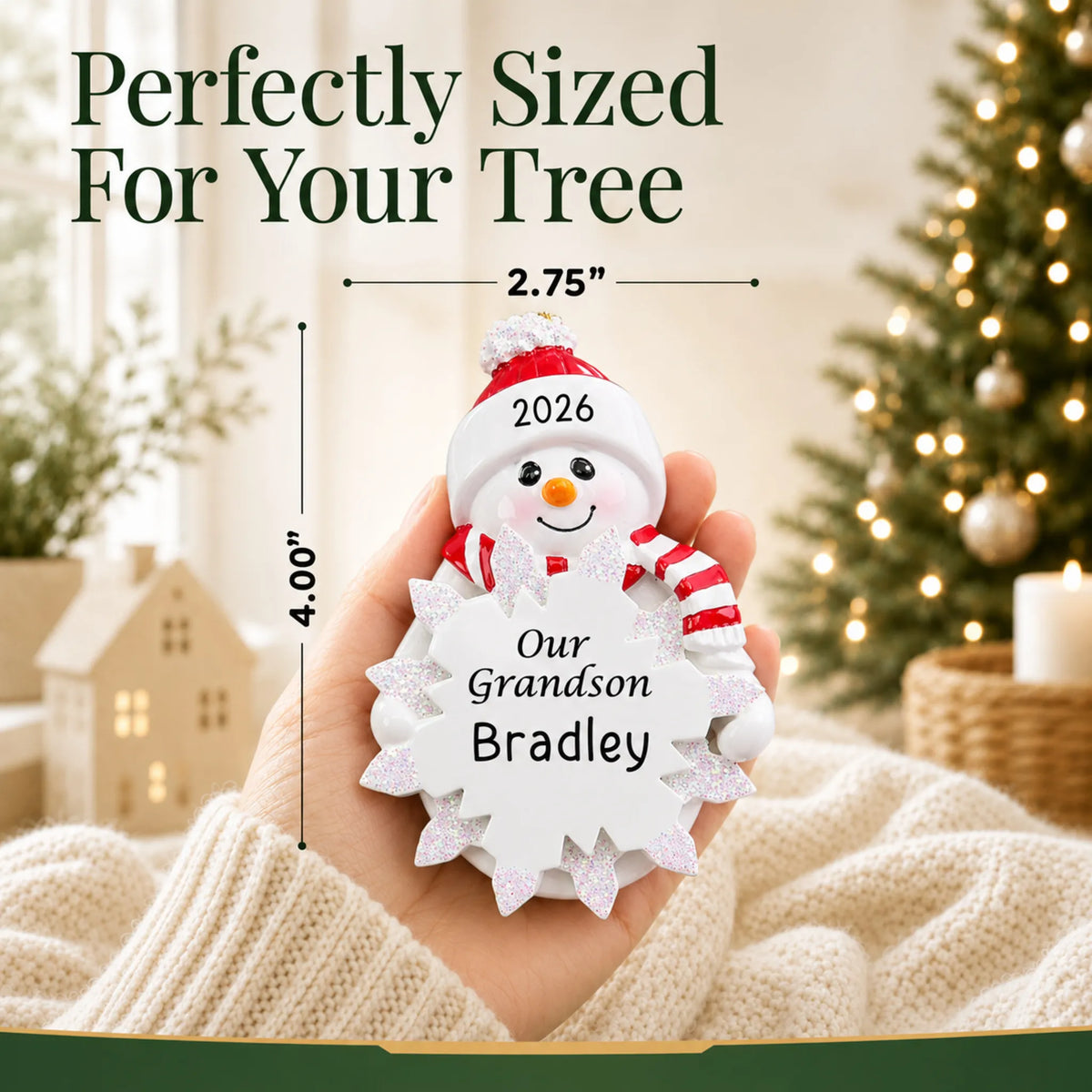 Size guide: the personalized grandson snowman christmas ornament shown in hand next to a Christmas tree