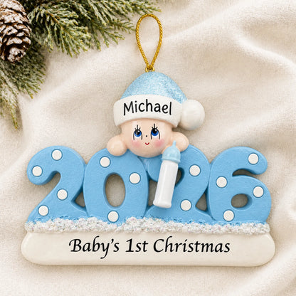 Personalized baby boy's 1st christmas 2026 ornament laid on a soft white knit blanket