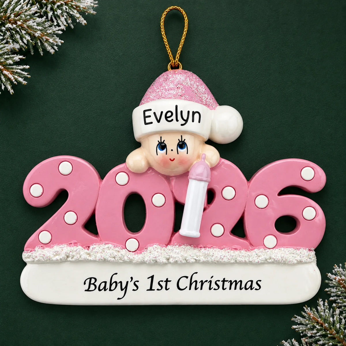 Personalized baby girl's 1st christmas 2026 ornament on a dark green pine background