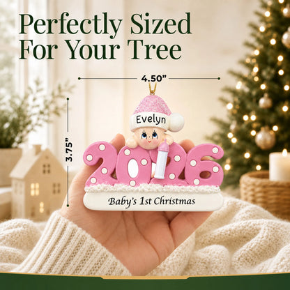 Size guide: the personalized baby girl's 1st christmas 2026 ornament is 4.50 in wide by 3.75 in tall, shown in hand