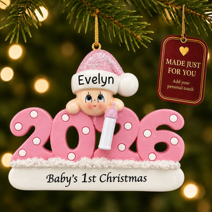 Baby girl's 1st christmas 2026 ornament hanging on a lit Christmas tree with a Made Just For You gift tag