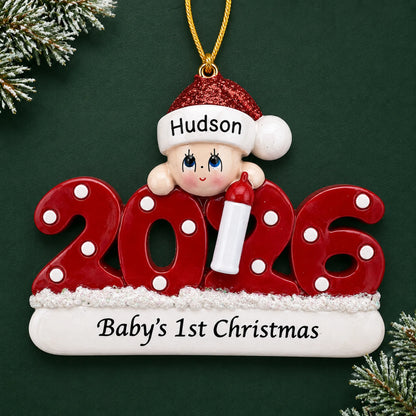 Personalized baby's 1st christmas 2026 ornament on a dark green pine background
