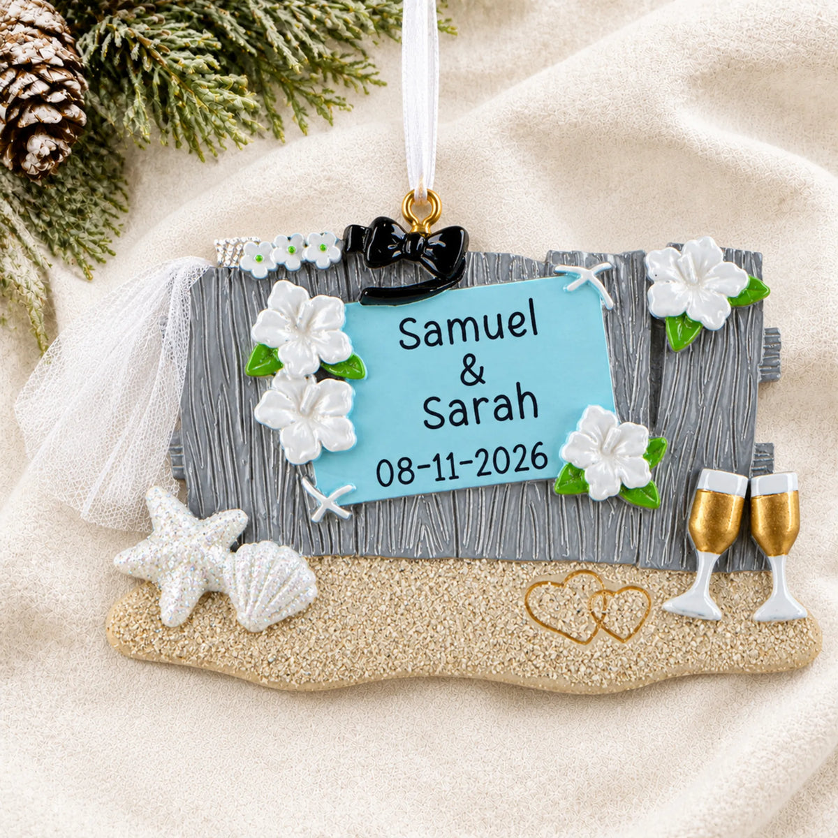 Personalized Beach Wedding christmas ornament laid on a soft white knit blanket