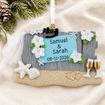 Personalized Beach Wedding christmas ornament laid on a soft white knit blanket