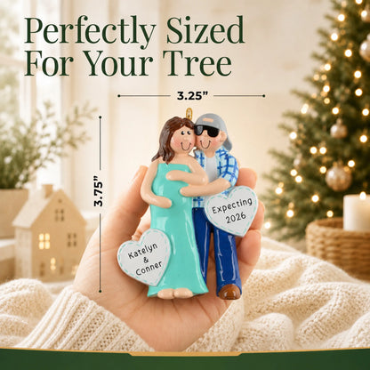 Size guide: the personalized Expecting Couple christmas ornament is 3.25 in wide by 3.75 in tall, shown in hand