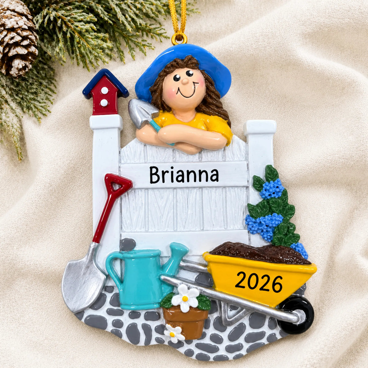 Personalized woman gardener christmas ornament laid on a soft white knit blanket