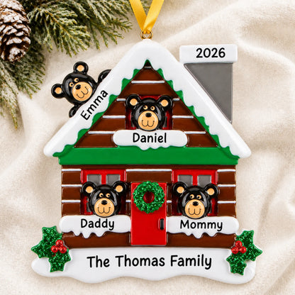 Personalized mountain cabin family of 4 christmas ornament laid on a soft white knit blanket