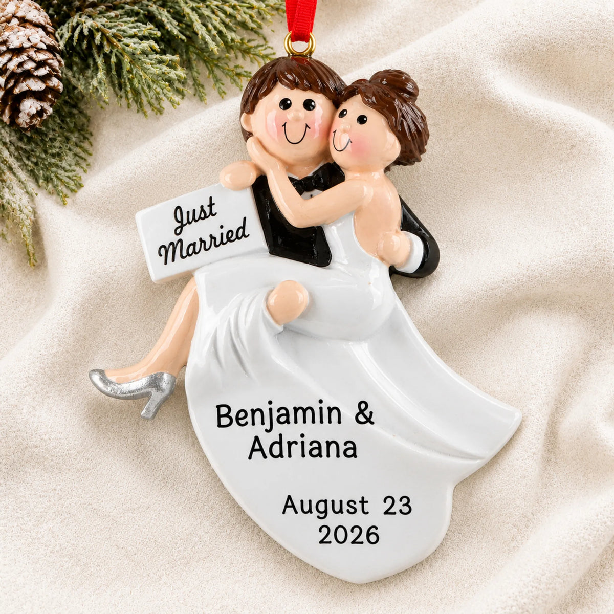 Personalized Just Married Bride & Groom christmas ornament laid on a soft white knit blanket